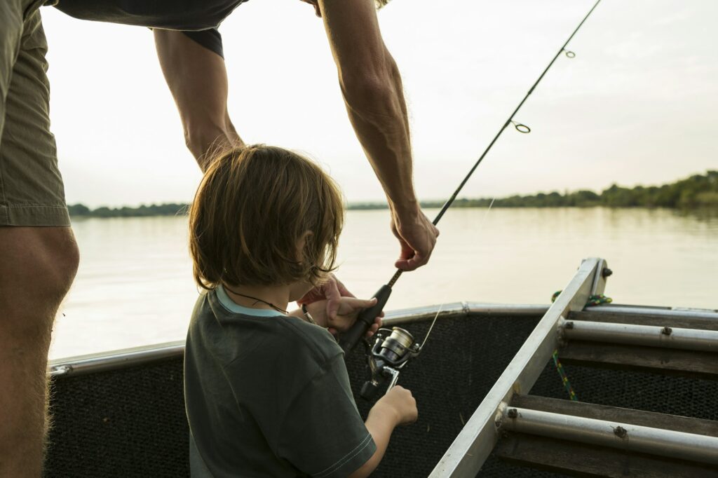 A five year old boy fishing from a boat for some Zambezi River Activities