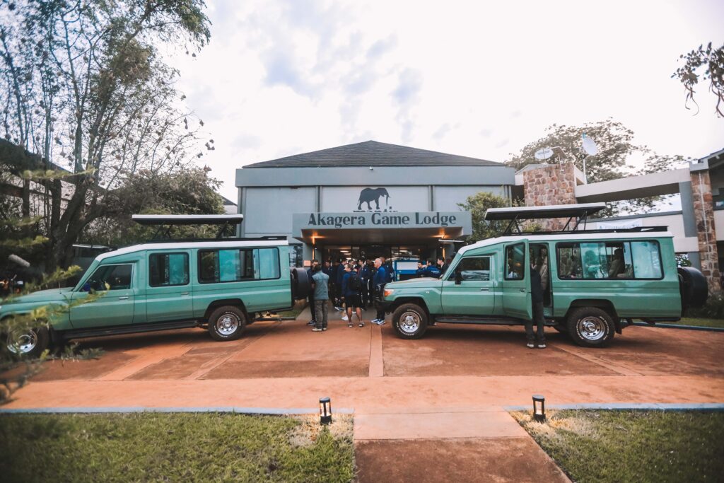 Tourists preparing for a safari at Akagera Game Lodge in Rwanda, with well-equipped safari vehicles. As the safest travel destination in Africa, Rwanda offers secure and well-organized wildlife adventures in its national parks.