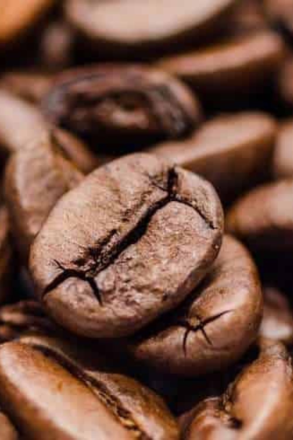 coffee-beans-g61f43fd14_1920 Close-up of roasted coffee beans with rich, dark brown tones, showcasing their texture and natural oils. Perfect for illustrating high-quality Arabica coffee from Rwanda.