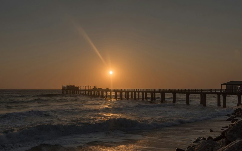 Silhouette of the historic jetty against setting sun in Swakopmund