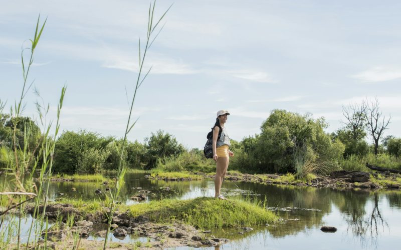 Young female tourist looking out over calm waters near Victoria Falls, Zimbabwe, Africa